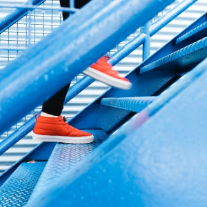 Person in red shoes walking up stairs